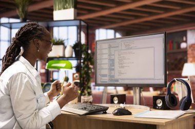 Programlama kodunu başarıyla çalıştıktan sonra bilgisayar monitöründen UI 'ye bakarak bunu kutlayan neşeli bir mühendis. Neşeli bilişim çalışanı kodu test ettikten sonra memnun