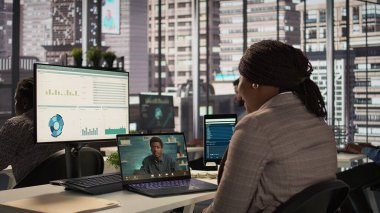 Siyahi direktör, yeni bir strateji için iş danışmanlarıyla bir video görüşmesi yapıyor, hedefler belirlemek için çevrimiçi konferansta uzaktan iletişimi kullanıyor. Uzmanla bağlantı. Kamera B.