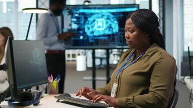 PC 'de kadın teknisyen kod yazıyor, sinirsel ağ API' leri geliştiriyor. Sistem yöneticisi, yazılım hatalarını yapay zeka teknolojisiyle gidermek için bilgisayar kullanıyor. Kamera A