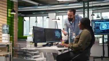 Mesai arasında eğlenen neşeli iş arkadaşları, bağlanma, pozitif ofis kültürü kavramı. İşyeri arkadaşlarının şakacı tartışmaları Kod A 'yı optimize etmek için yapay zekayı kullanırken, Kamera A