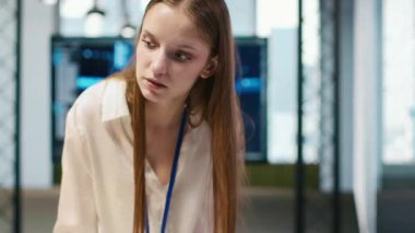 Küçük Dev ve tekerlekli sandalyedeki iş arkadaşı yazılım uygulamaları geliştiriyor, kodu optimize ediyor. Belden aşağısı felçli kadın teknisyen ve meslektaş, A kamerasındaki darboğazları çözmek için yapay zeka kullanıyor.