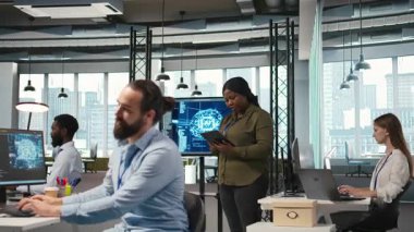 Kadın programcı, yazılım sorunlarını düzeltmek ve sistem istikrarını iyileştirmek için yapay zeka algoritmalarını tablet üzerinde kodluyor. Teknoloji başlangıç ofisindeki kadın ayarları ayarlamak için aygıt, kamera A 'yı kullanıyor.