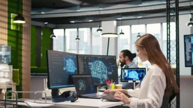 Ofisteki kadın programcı yapay zeka öğrenme sistemlerini iş akışlarını düzene sokacak şekilde entegre ediyor. IT çalışanı sinirsel ağlar yapay zeka, teknoloji aşırı yükleme konsepti, kamera A