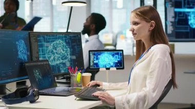 Yüksek teknoloji firma ofisinde bilişim uzmanı yapay zeka modelleri geliştirmek için sinirsel ağlar kullanır. Kadın mühendis, aygıtlar üzerinden görevleri, ekranlardaki ilerlemeyi, kamera A 'yı izlemek için yapay zeka kullanır.