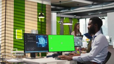 Yazılım geliştiricisi yeşil ekran bilgisayarında yapay zeka kullanarak performansı ve tahminleri optimize ediyor. Ofisteki eğitim makinesindeki adam modelleri öğrenmek için örnek bilgisayar, kamera A 'yı kullanıyor.