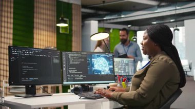 Kod yazmak için bilgisayar kullanan kadın teknisyen, makine öğrenme API 'leri geliştiriyor. Afro-Amerikalı kadın yazılım hataları ve hataları için yapay zeka, kamera A kullanıyor.