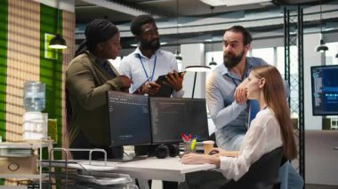 Yeni başlayan arkadaş ofiste arkadaş ediniyor, makine öğrenme teknolojisini kullanmayı öğreniyor. İş yerindeki neşeli genç kız iş arkadaşlarıyla sohbet ederken yapay zeka öngörüsü modelleri, kamera A kullanıyor.