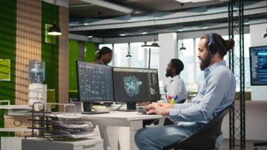 Yazılım geliştiricisi AI dili model yardımı ile kodlama yapıyor, müzik dinliyor. Kulaklık takan programcı LLM yardımcı önerilerini kod düzenleyicisi kamera A 'ya entegre ediyor