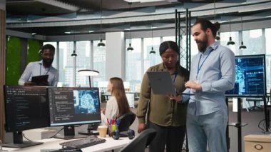 Ofisteki takım çalışması programcıları yapay zeka ölçümlerini gözden geçiriyorlar, performans gösterge panellerini izliyorlar. Bilgisayar ve kamera A 'daki araçları kullanarak sinirsel ağları ayarlayan teknoloji şirketinin iş arkadaşları.