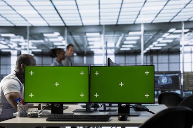 Yapay zeka ve makine öğrenme araçlarını kullanarak veri merkezi otomasyonu yapan bir adam. Sunucu merkezi işlemlerinde yeşil ekran PC kullanarak yapay zeka entegre eden programcı