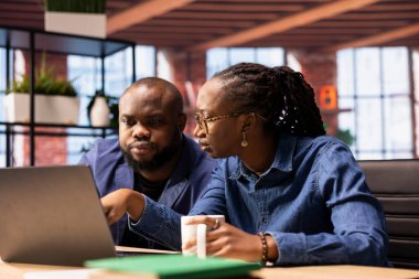 Genç yetişkinler ev ofislerinde dizüstü bilgisayarlarındaki mali raporları analiz ediyorlar, üretkenlik için online serbest çalışma görevlerini yönetmek için takım çalışması yapıyorlar. Siyah çift bağımsızlığını kazandı.