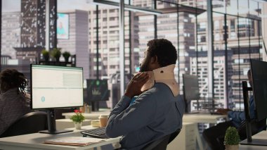 Servikal tasması olan yaralı bir çalışan yeni bir iş projesinde çalışıyor, boynu kırılmış bir şekilde masada oturmaya çalışıyor. Afrikalı Amerikalı şirket ortağı görevleri çözmeye çalışıyor. Kamera B.