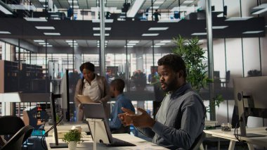 Afrikalı Amerikalı analist hissedarlarla aylık gelirleri tartışıyor video konferans görüşmelerine katılıyor. Girişimci daha fazla fon ve online iletişim istiyor. Kamera B.