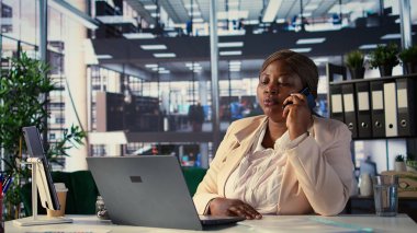 Profesyonel CEO iş stratejisi ve müşteri hedeflerini konuşmak için telefon görüşmesi yapıyor. Müzakereler, girişim içinde karar verme ve mali planlamayı ön plana çıkarıyor. Kamera B.