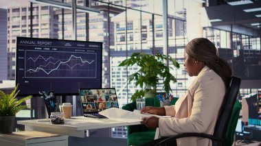 Profesyonel güdümlü CEO yatırımcılarla video görüşmelerini paylaşıyor, üst düzey bir şehir ofisinde kâr ve satışlar hakkında konuşuyor. Kadın lider şirketini genişletmek istiyor. Kamera B.