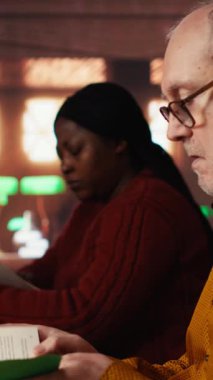 Üniversite kampüs kütüphanesindeki bir tez projesini araştıran dikey video erişkin kız öğrenci akademik başarı için ilham ve adanmışlık göstermektedir. Evrak işleriyle uğraşıyorum. Kamera B.