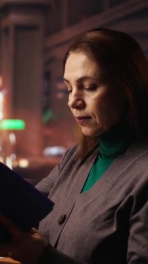 Dikey Video Kararlı Kadın kütüphanedeki özel bir kitaptan tez alıntıları yazıyor, olgun bir öğrenci yüksek öğrenim hedefi doğrultusunda çalışıyor. Sessiz bir kampüs çalışma alanında akademik materyaller