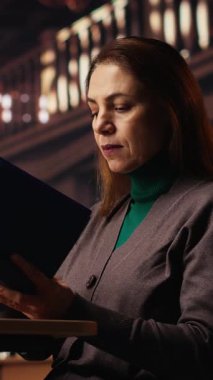 Üniversite kampüs kütüphanesinde okuyan ve yazan dikey videolu olgun kadın, entellektüel hırs ve ömür boyu öğrenme ve kişisel başarı için kendini adayarak tez üzerinde çalışıyor. Kamera B.