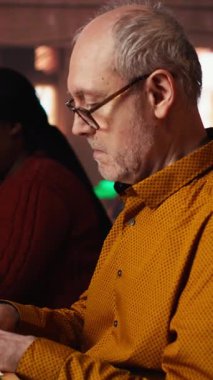 Dikey Video Yetişkin Kadın kütüphanede ders çalışıyor ve ders notlarına odaklanıyor ve araştırmadaki kararlılığını gösteriyor. Üniversite tezine hazırlanıyor.