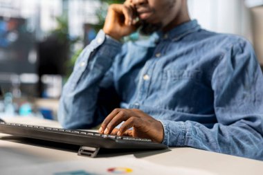 İş adamı, iş yerindeki bilgisayarında performans ölçümlerini analiz ediyor. Stratejik planlamayla ilgilenirken, şirketin başarılı sonuçlara yönelik hedeflerini desteklemek amacıyla verileri gözden geçirir..