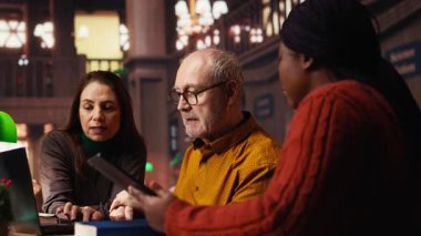 Olgun akademisyen meslektaşlar, ders kitaplarından temel fikirleri kopyalayarak üniversite ödevleri veya sınavları için belgeler hazırlarlar. Sakin bir halk kütüphanesinde araştırma ve eğitim. Kamera B.