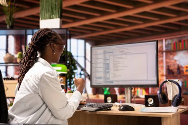 İş istasyonundaki programlamada gülümseyen kodlayıcı, kodları başarıyla yazdıktan sonra kutlama yapıyor. İç işlerindeki kadın, son teslim tarihinden önce hata ayıklamayı başardıktan sonra memnun oldu