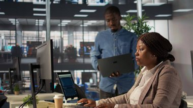 Afrika kökenli Amerikalı takım üyeleri arşivlenmiş dosyalarla idari görevler üstlendi, veri raporlarını ve kurumsal analizleri inceleyerek girişim hedeflerine uyum sağladılar. Kamera B.