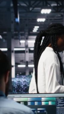 Veri merkezi mühendislerinden oluşan dikey video ekibi evrakları inceliyor ve veri tabanlarını analiz etmek için derin öğrenme algoritmaları kullanıyor. Çok ırklı sunucu çiftliğindeki çalışanlar veri örneklerini tanımak için yapay zeka kullanıyorlar