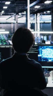 Sunucu odasında bulunan dikey video mühendisi cihazlardaki altyapı teşhislerini incelemek için yapay zekayı kullanıyor. Bilgi işlem uzmanı, sistemi korumak için yapay zeka kullanarak performans verilerini analiz ediyor.