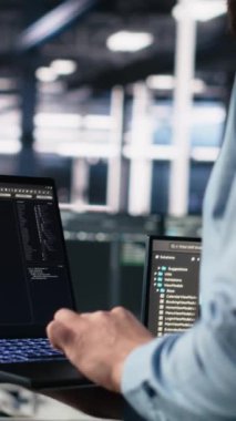 AI LLM sohbet robotunu kullanarak sinirsel ağı izlemek için dizüstü bilgisayar kullanan dikey video veri merkezi programcısı. Sunucuların makine öğrenmesini denetlemek için bilgisayardaki yapay zekayı kullanan işçiler, kamera