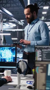 Sunucu odası mühendisinin yapay zeka kullanarak cihazlardaki altyapı teşhislerini inceleyen dikey video yöneticisi denetimi. Veri merkezinde veri analizinde bilişim uzmanını denetleyen teknoloji şirketi denetçisi