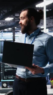 Dikey Veri Merkezi Yöneticisi hissedarlara yapay zeka teknolojisini sunarak öngörücü bakım becerilerini gösteriyor. Sunucu merkezi hakkında yatırımcılara brifing veren adam yapay zeka