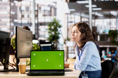Yönetici yardımcısı, bilgisayarındaki veri bilgilerini gözden geçirip izole edilmiş fotokopi alanının yanında bir mali rapor hazırladı. Örgütsel ilerleme ve görev yönetimi için bir öngörü geliştiriliyor.
