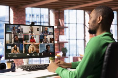 Evden yapılan video görüşmesi sırasında iş arkadaşlarıyla görüşen, takvim randevuları düzenleyen uzaktan çalışan. İşçi şirket etkinliğine hazırlanıyor, meslektaşlarıyla uzaktan video konferans yapıyor