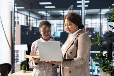 Modern bir cihazın arşivlenmiş verilerini analiz eden profesyonel ekip, şirket performansını artırmak ve uzun vadeli büyüme için kurumsal çözümler ve mali planlama görevleri üzerinde işbirliği yapmaktadır.