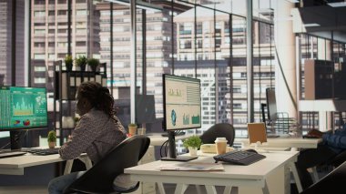 Erkek yönetici analist finansal bir rapor hazırlar ve verileri gözden geçirir, örgütsel ilerleme için bir öngörü geliştirir. Siyahi adam görev yönetimi ve strateji planlaması yapıyor. Kamera B.