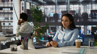 Hintli şirket yöneticisi uzaktan bir toplantıya katılır, performans ölçümlerini ve iş operasyonlarını gözden geçirir. Proje yönetimini düzene sokmak için dijital iletişim araçları kullanılıyor. Kamera B.