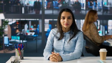 POV Hintli çalışanı ekibiyle çevrimiçi bir toplantı yapıyor, proje özetleri ve yaklaşan teslim tarihlerini tartışıyor. İletişim ve zaman yönetimini garantiye almak için video çağrısını kullanıyor. Kamera A.