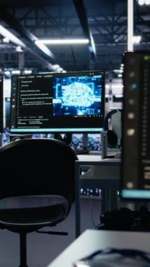 Veri merkezinde, makine öğrenme kodlarını gösteren monitörlerle birlikte dikey video yapay zeka geliştirme çalışma istasyonları. Sinir ağı yapılarının algoritma performansını izlemek için kullanılan sunucu çiftliği bilgisayarları