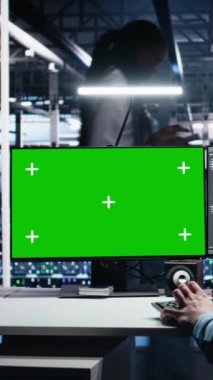 Yapay zeka ve verimlilik için yapay zeka sistemlerini kontrol eden dikey video veri merkezi mühendisi. Sunucu merkezindeki izole ekran bilgisayarında yapay zeka kullanan bilişim uzmanı, kamera A