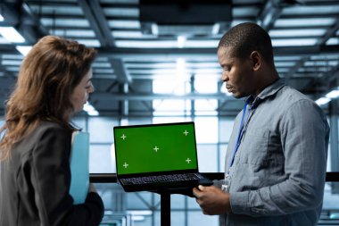 Veri merkezinde yeşil ekran dizüstü bilgisayar kullanan mühendis, sunucu virtüözleştirme stratejilerini geliştiren, küme düğümlerini yapılandıran, yönlendirme kurallarını ayarlayan, verimli iş akışlarını koruyan