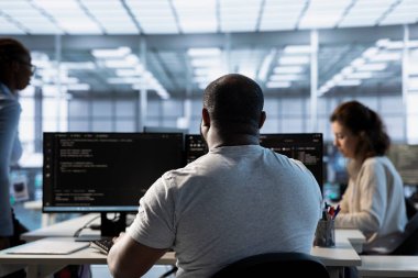 Sunucu merkezindeki yönetici, hackleme saldırılarına karşı verileri korumakla görevli meslektaşlarının yanında. Afrikalı Amerikalı işçi ve iş arkadaşları veri merkezini yetkisiz erişime karşı koruyor