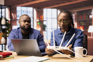 Siyah çift ağ sorunlarını ve sinyal kaybını analiz ediyor, internet hızını iş ve yayın için optimize edecek şekilde yönlendirici konumlarını ayarlıyorlar. Evde çalışmakla boğuşuyorum..