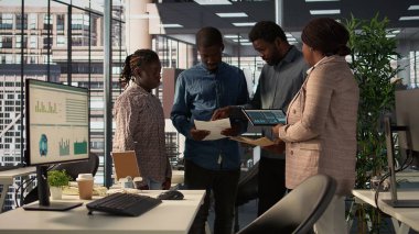 Toplantı sırasında bir finans dosyasına ait arşivlenmiş verileri analiz eden profesyonel ekip, uzun vadeli büyümenin performansını artırmak için kurumsal çözümler ve görevler üzerinde işbirliği yapıyor. Kamera B.