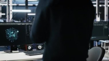 Yönetim veri merkezine giriyor, yapay zeka kontrollerini bilgisayarda gözden geçiriyor. IT uzmanı sunucu çiftliği masasında çalışmaya başlıyor, yapay zeka sistemleri yapılandırmasını optimize ediyor, kamera A