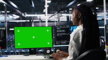 Veri merkezi yöneticisi yeşil ekran PC kullanarak AI sistemlerini yöneten teknisyen ekibini denetliyor. Denetmen, sunucu merkezinde çalışan meslektaşlarının çalışmalarını kontrol ediyor. Model bilgisayar, kamera A kullanarak.