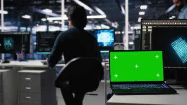 Veri merkezi mühendisi kroma anahtar dizüstü bilgisayarda sinirsel ağ yazılım geliştirme üzerinde çalışıyor. Sunucu odası bilişim uzmanı izole ekran defteri, kamera A kullanarak makine öğrenme teknolojisi uyguluyor.