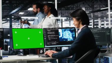 Veri merkezi teknisyeni yapay zeka sistemlerini modelleme bilgisayarı kullanarak yönetiyor. Sunucu merkezindeki yeşil ekran bilgisayarda yapay zeka kullanan teknoloji uzmanı, kamera A