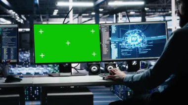Yapay zeka sistemlerini kontrol eden veri merkezi mühendisi. Model PC kullanarak zaman ve verimlilik için. Sunucu merkezindeki izole ekran bilgisayarında yapay zeka kullanan bilişim uzmanı, kamera A