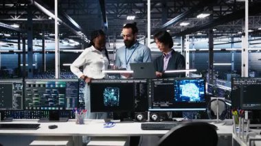 Sunucu odasındaki gülümseyen mühendislerin portresi altyapı teşhislerini gözden geçirmek için yapay zekayı kullanıyor. Veri merkezindeki neşeli bilişim çalışanları yapay zeka ve kamera A kullanarak performans verilerini analiz ediyorlar.